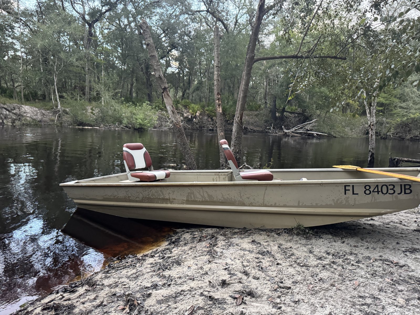 A boat pulled up on a white sandbar on the St. Marys River at River & Roots Ranch