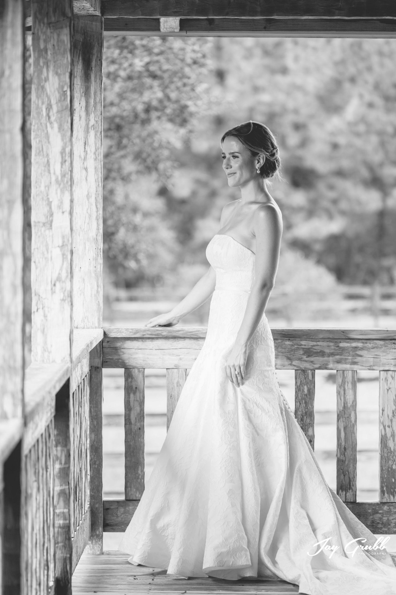 Black-and-white portrait of the bride leaning on the porch railing