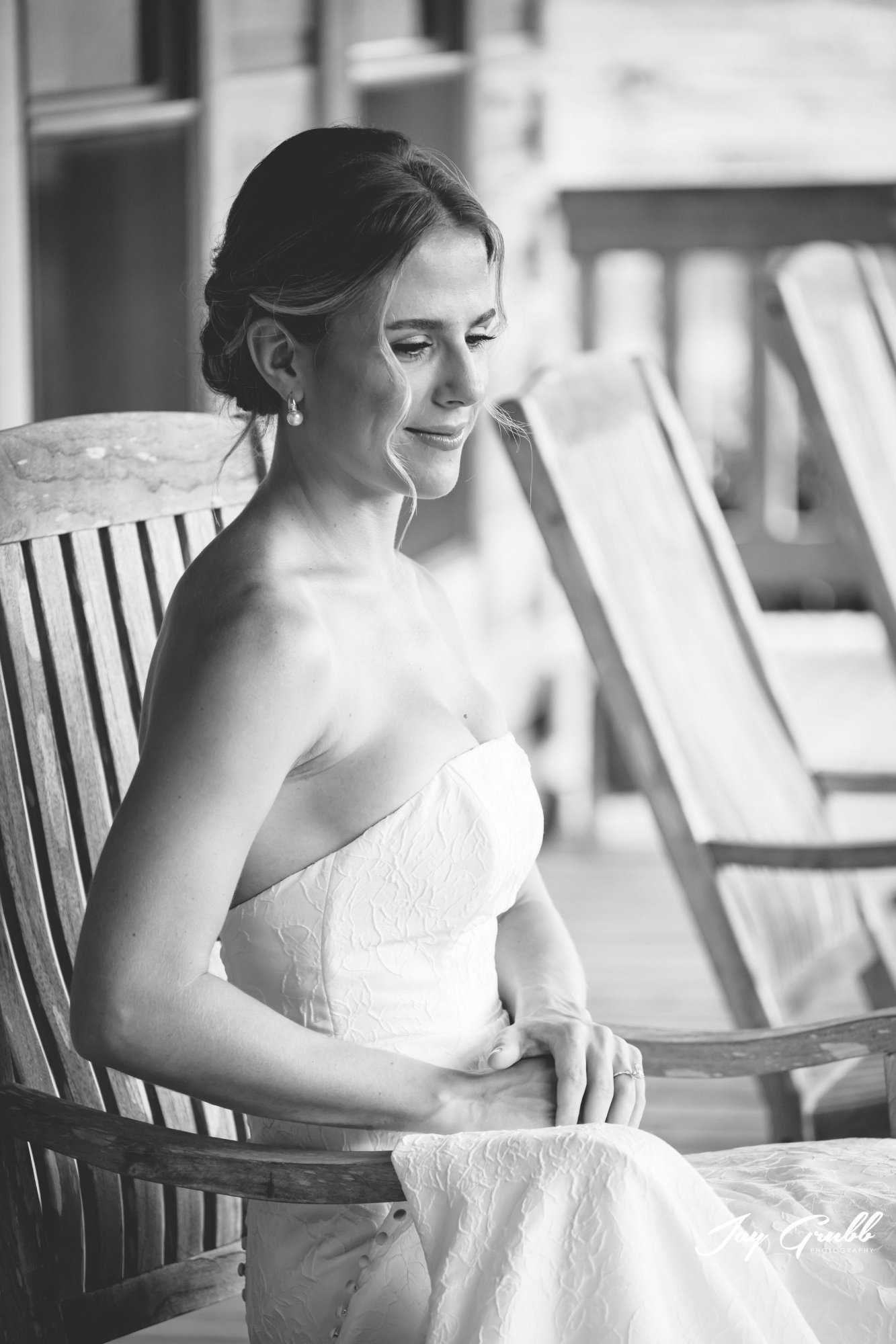 Black-and-white portrait of the bride resting in a rocking chair on the porch