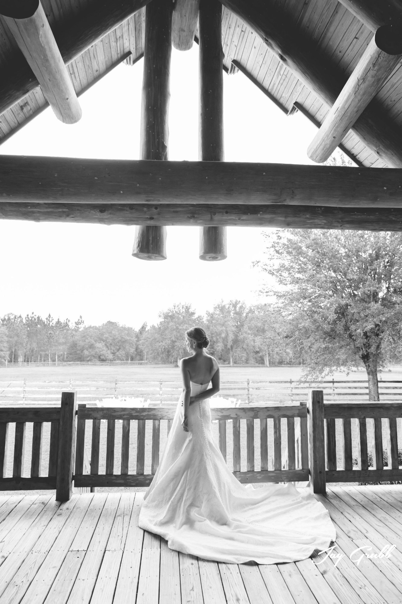 Black-and-white portrait of the bride facing the pasture from the covered porch