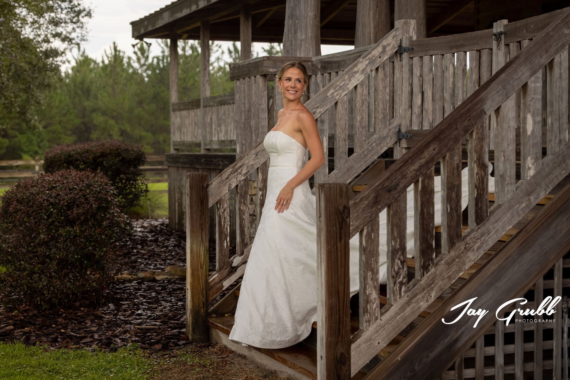 Close-up of black studded cowboy boots peeking out from beneath a white dress