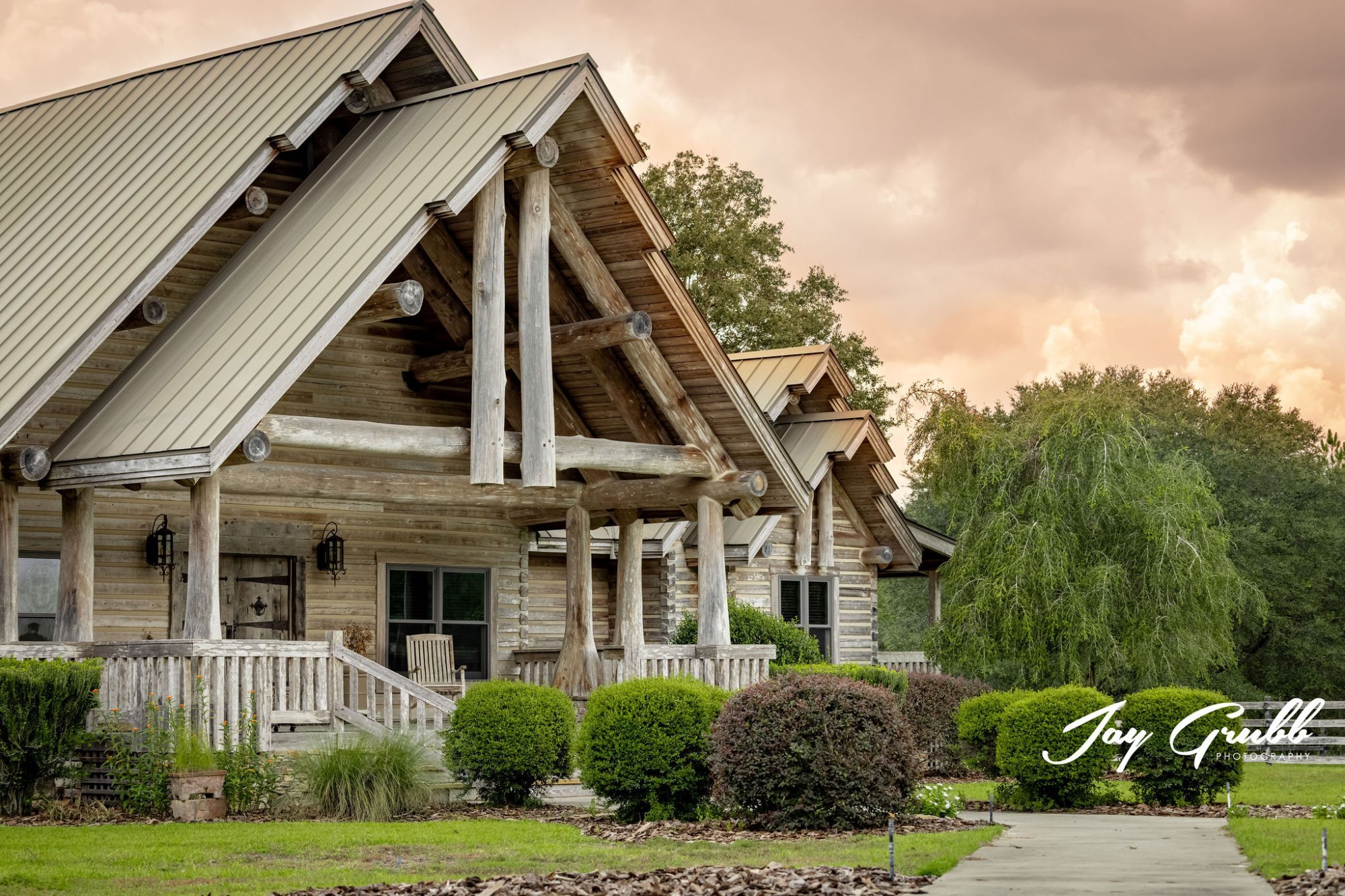 The ranch house at golden hour beneath a peach and gold sky, set for a wedding weekend